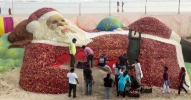 فنان هندي يبهر العالم بنحت تمثال عملاق لبابا نويل باستخدام 1.5 طن من التفاح